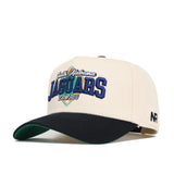 The South Alabama Ballpark Hat by No Rivals is a cream cotton cap with a black brim, green underbill, and "South Alabama Jaguars Est. 1963" embroidered in blue, green, and yellow. NR is stitched on the side of this structured fit cap.