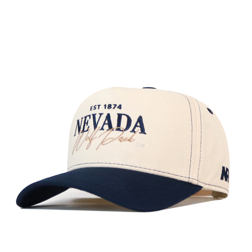The No Rivals Nevada Wolf Pack Vintage Hat is a beige and navy blue baseball cap featuring “EST 1874 NEVADA Wolf Pack” embroidered on the front and “NV” on the side; this officially licensed cap includes a snap back closure for a comfortable, custom gameday fit.
