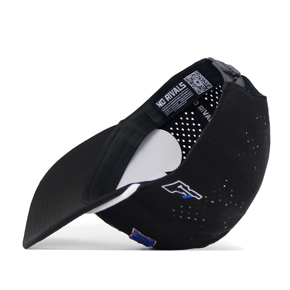 A Boise State Golf Hat by No Rivals in black is displayed on its side, featuring an adjustable snap back strap, ventilation holes, and visible inner tags. An officially licensed blue and white embroidered Boise State logo appears on the side of the cap.