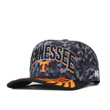 Show your Volunteer pride with the No Rivals Tennessee Volunteers 2026 Military Appreciation Hat. This officially licensed snapback features a bold black and gray camouflage design, “TENNESSEE” and a large orange T embroidered on the front, and vibrant orange wing-inspired accents on the brim. The side is detailed with AR stitching, making this hat a striking choice for any fan.
