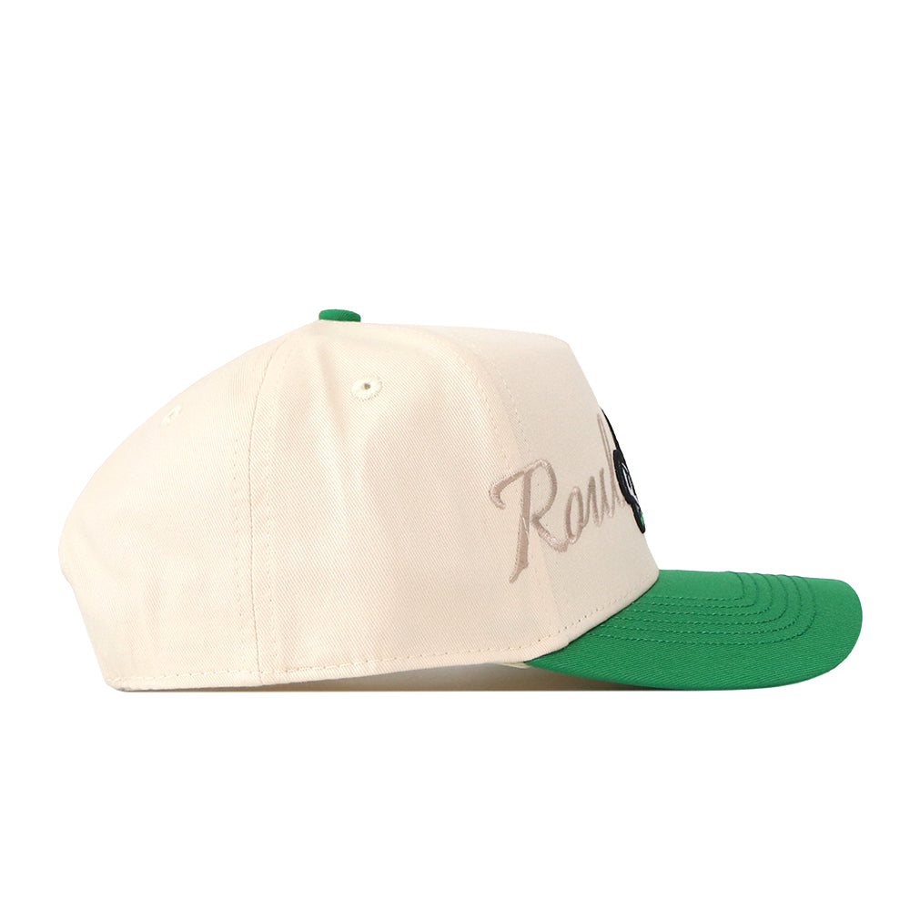 A side view of the No Rivals Tulane Mardi Gras Roulez Wave Hat highlights its cream-colored body and green brim. The word “Roulez” is subtly embroidered in beige cursive letters on the side, adding an elegant logo detail for a refined touch.
