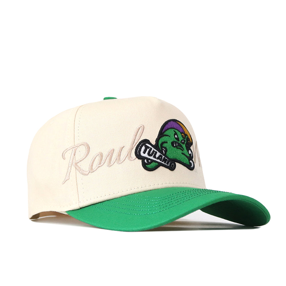 Introducing the Tulane Mardi Gras Roulez Wave Hat by No Rivals—a cream-colored baseball cap with a green brim, showcasing an embroidered “Roul” logo in cursive and a playful cartoon green gator sporting a purple hat with “TULALU” on a bone in its mouth. This snapback is the perfect addition to your gameday fit!.