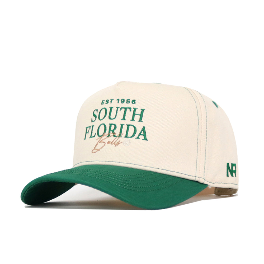 The No Rivals USF Vintage Hat features a cream and green snapback design with "EST 1956 SOUTH FLORIDA Bulls" embroidered in green and gold, NR stitched on the side, a green brim and button, crafted from high-quality cotton for true fans.