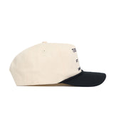 A side view of the Wake Forest "The Couch" Walk-Off Hat by No Rivals, a beige cotton cap with a black curved brim, visible stitching, and an embroidered front design partially seen from this angle.