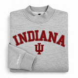 Folded heather grey oversized Indiana Mock Neck sweatshirt featuring INDIANA and a university logo in red lettering, with No Rivals brand text printed on the sleeve cuff.