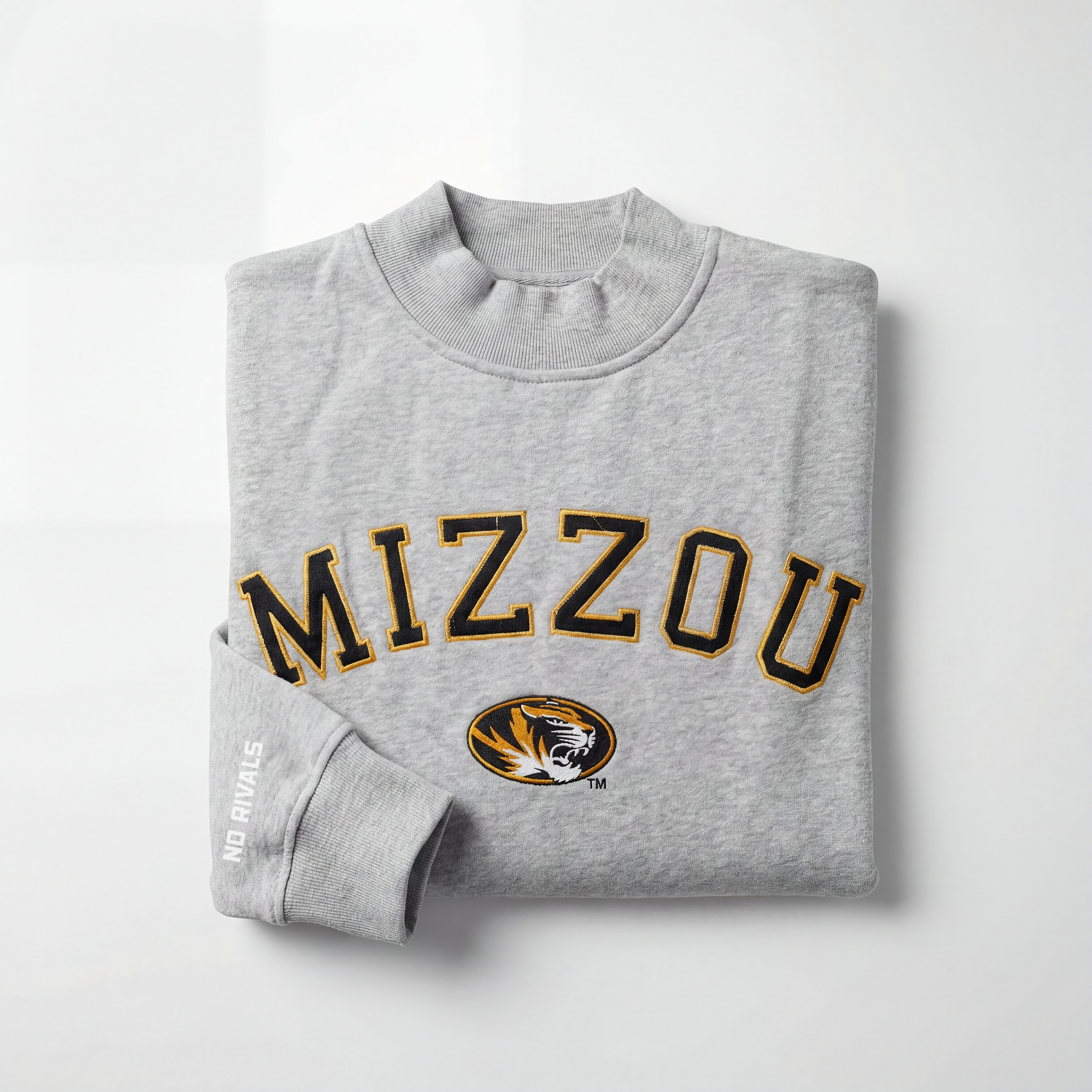 The No Rivals Mizzou Mock Neck is a heavyweight cotton, oversized gray sweatshirt with “MIZZOU” in bold black and gold, the University of Missouri tiger logo beneath, and “NO RIVALS” printed in white on the sleeve.