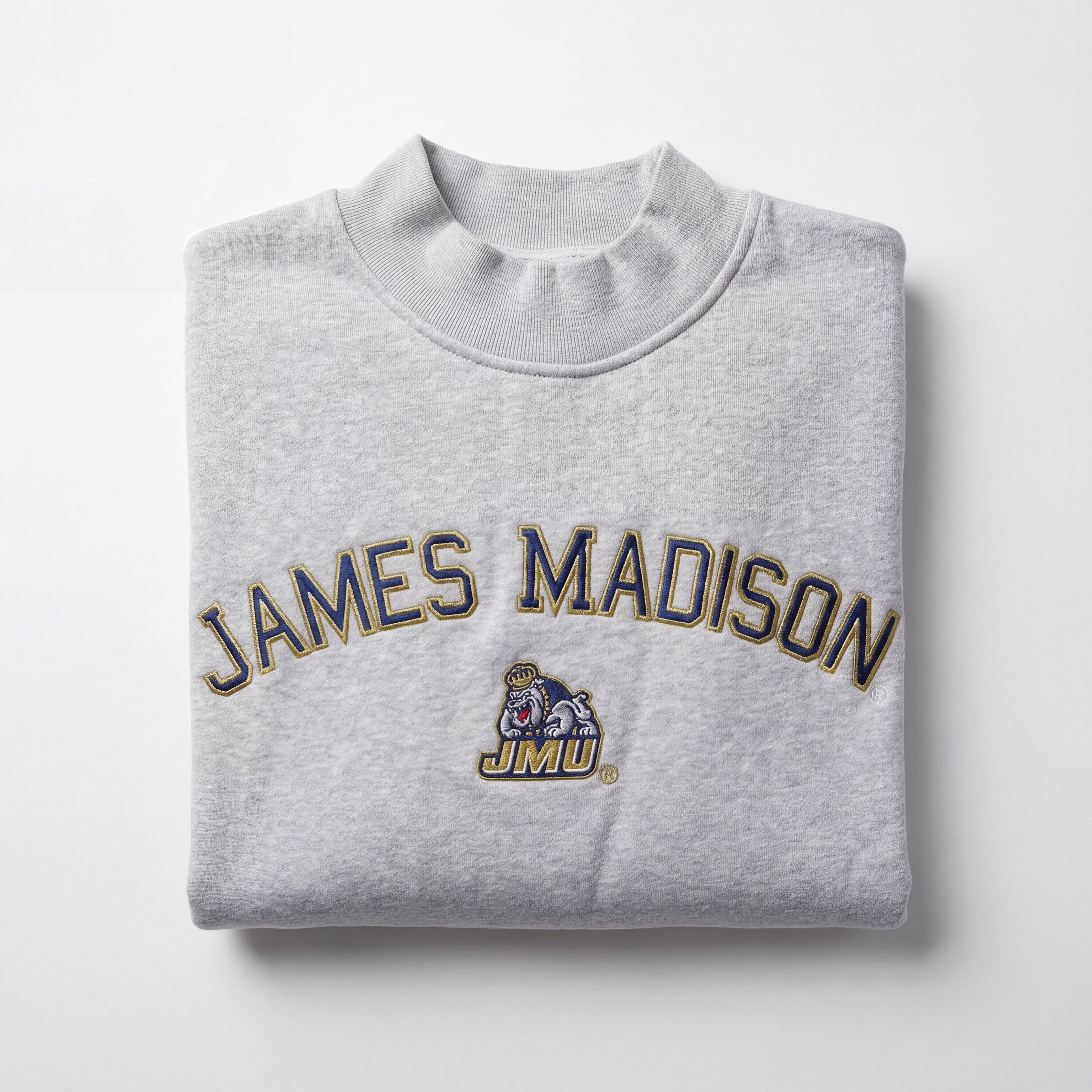 The No Rivals JMU Mock Neck is a folded light gray heavyweight cotton sweatshirt featuring "James Madison" in large letters and the JMU mascot logo on the front, shown on a white background.