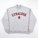 The No Rivals Syracuse Mock Neck is a gray heavyweight cotton sweatshirt featuring an oversized fit, bold orange and navy "SYRACUSE" lettering, and a cartoon orange mascot in the center, shown laid flat on a white background.