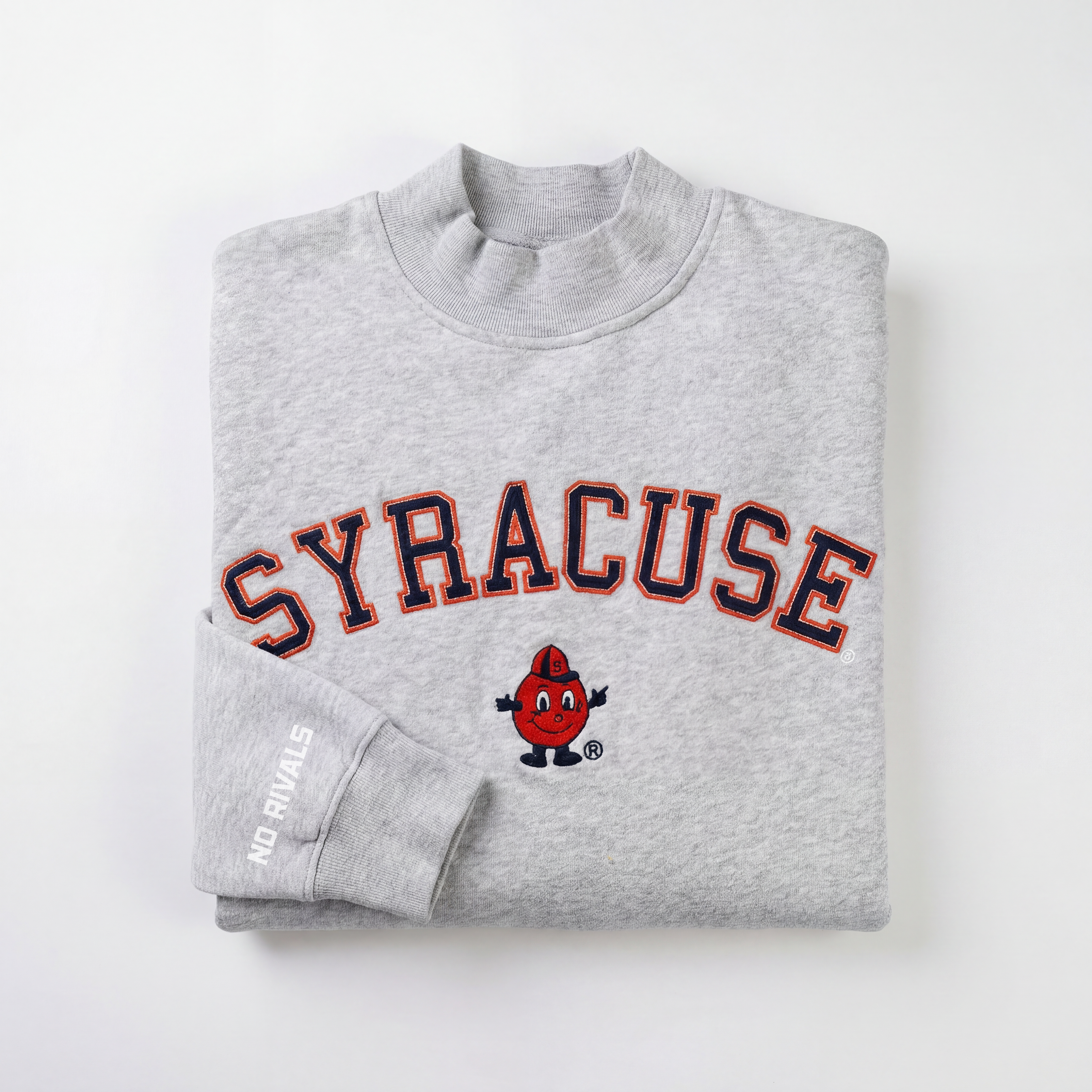 The Syracuse Mock Neck by No Rivals is a folded gray sweatshirt with “SYRACUSE” in bold orange and navy, Otto the Orange in a blue hat, and “NO RIVALS” text on one sleeve. Made from heavyweight cotton with a soft fleece interior.