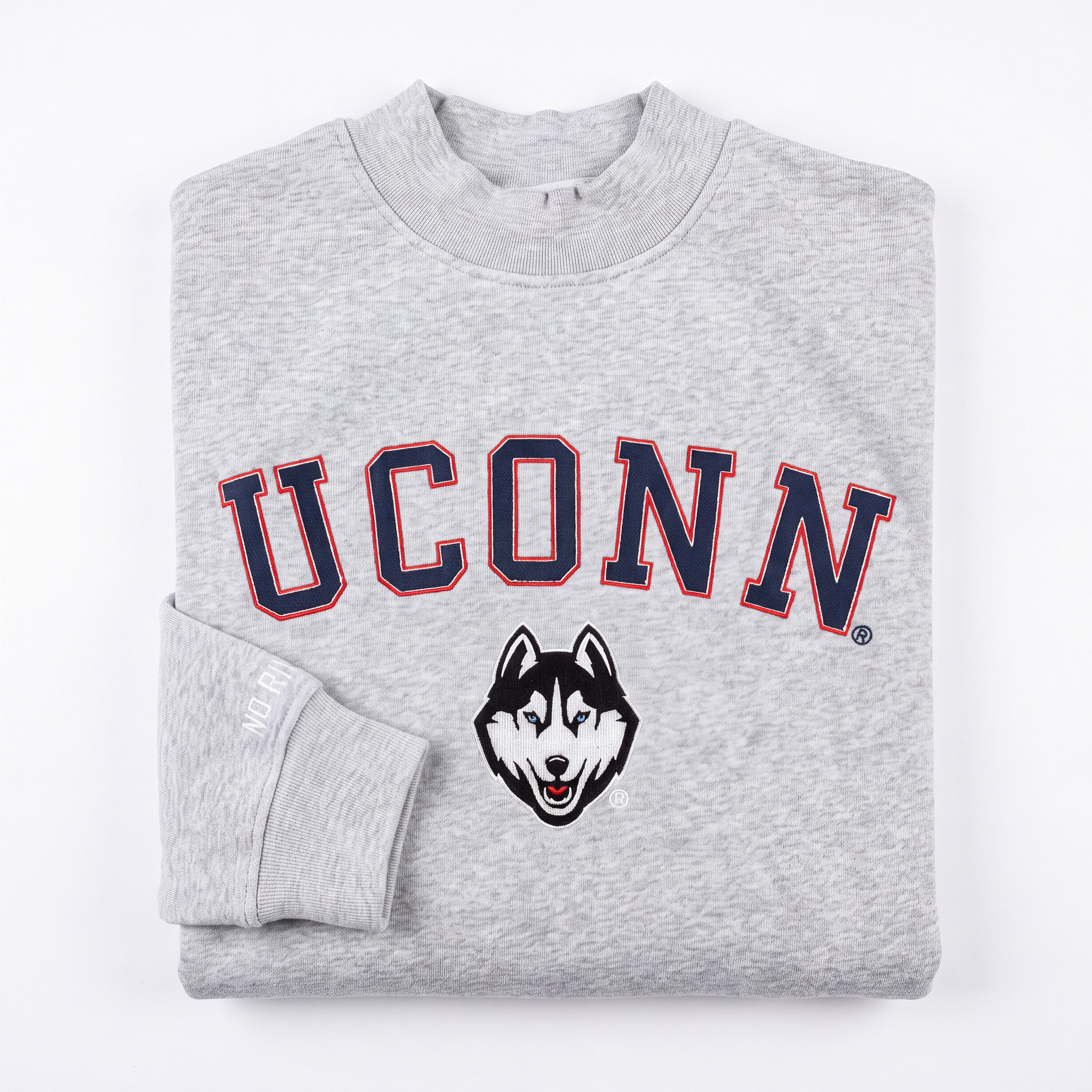 A folded gray UConn Mock Neck sweatshirt by No Rivals, featuring "UCONN" in large navy and red letters with a husky face logo below the text. Made from heavyweight cotton, one sleeve is neatly folded over the front.