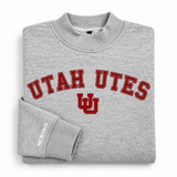 Folded, oversized grey No Rivals Utah Mock Neck sweatshirt featuring UTAH UTES in red collegiate lettering and a red interlocking UU logo on the chest.