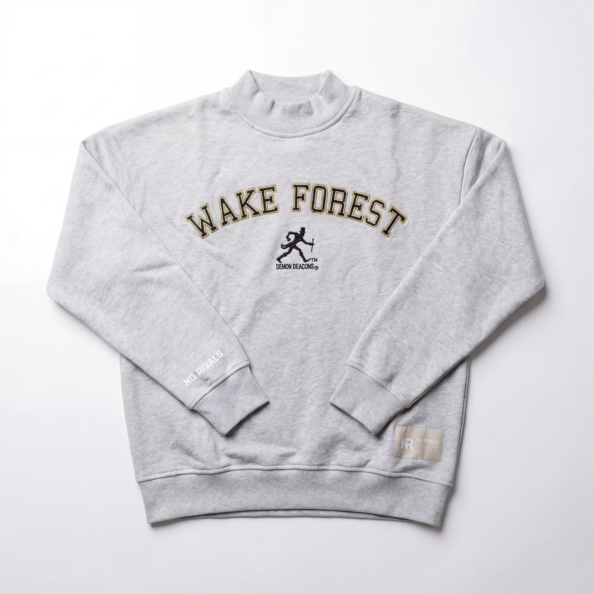 The Wake Forest Mock Neck by No Rivals is a light gray heavyweight cotton sweatshirt featuring bold black and gold WAKE FOREST lettering, a running figure graphic, DEMON DEACONS below, “NO RIVALS” on the cuffs, and a small hem tag.