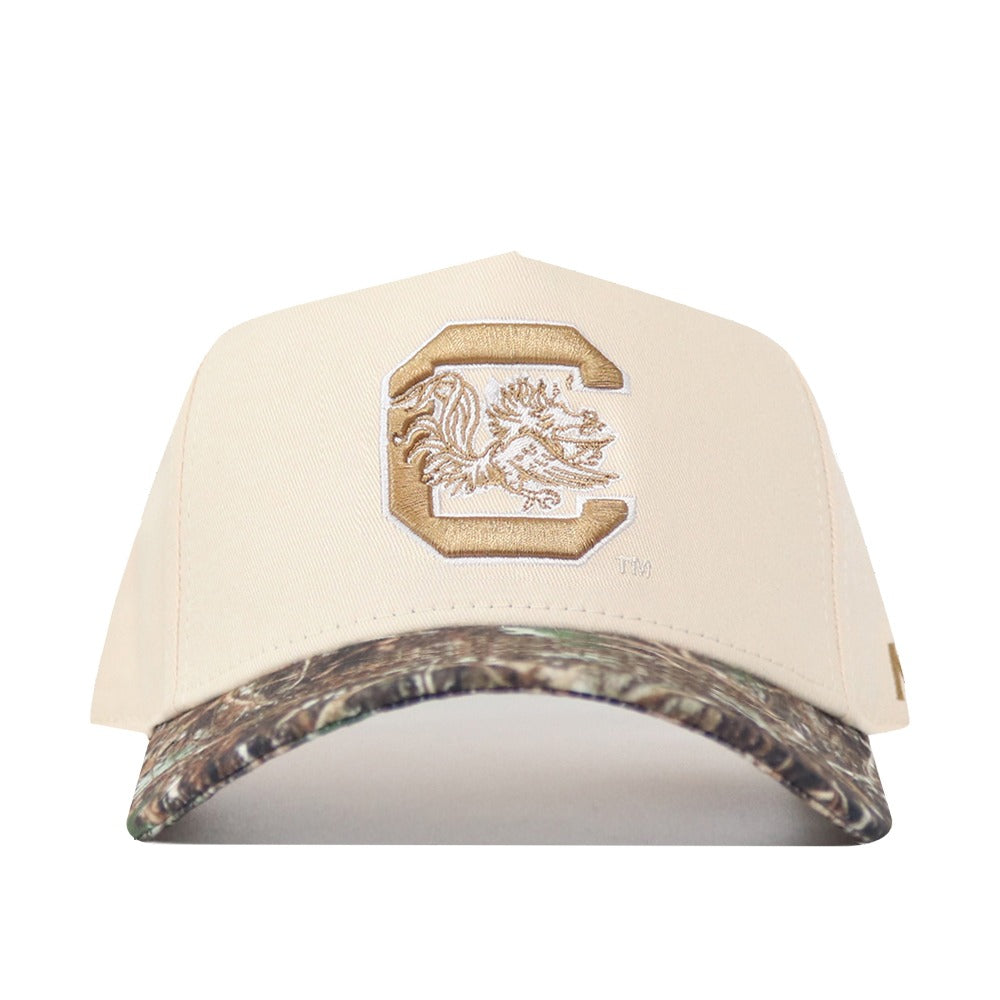 Beige cap with a logo on the front and camouflage bill on a white background