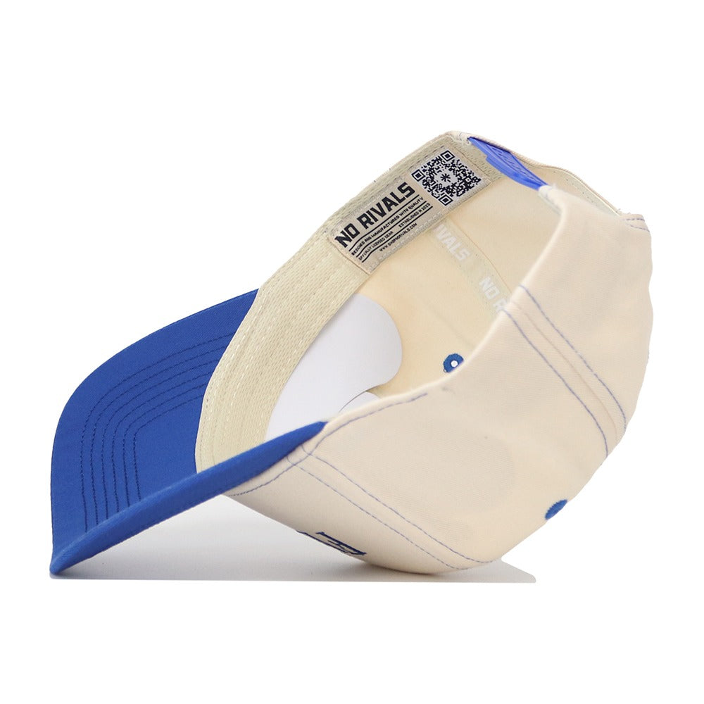 The Florida Vintage Hat is a cream and blue baseball cap seen from underneath, featuring a curved blue brim, cream-colored cotton fabric, visible stitching, and an inside label reading NO RIVALS.