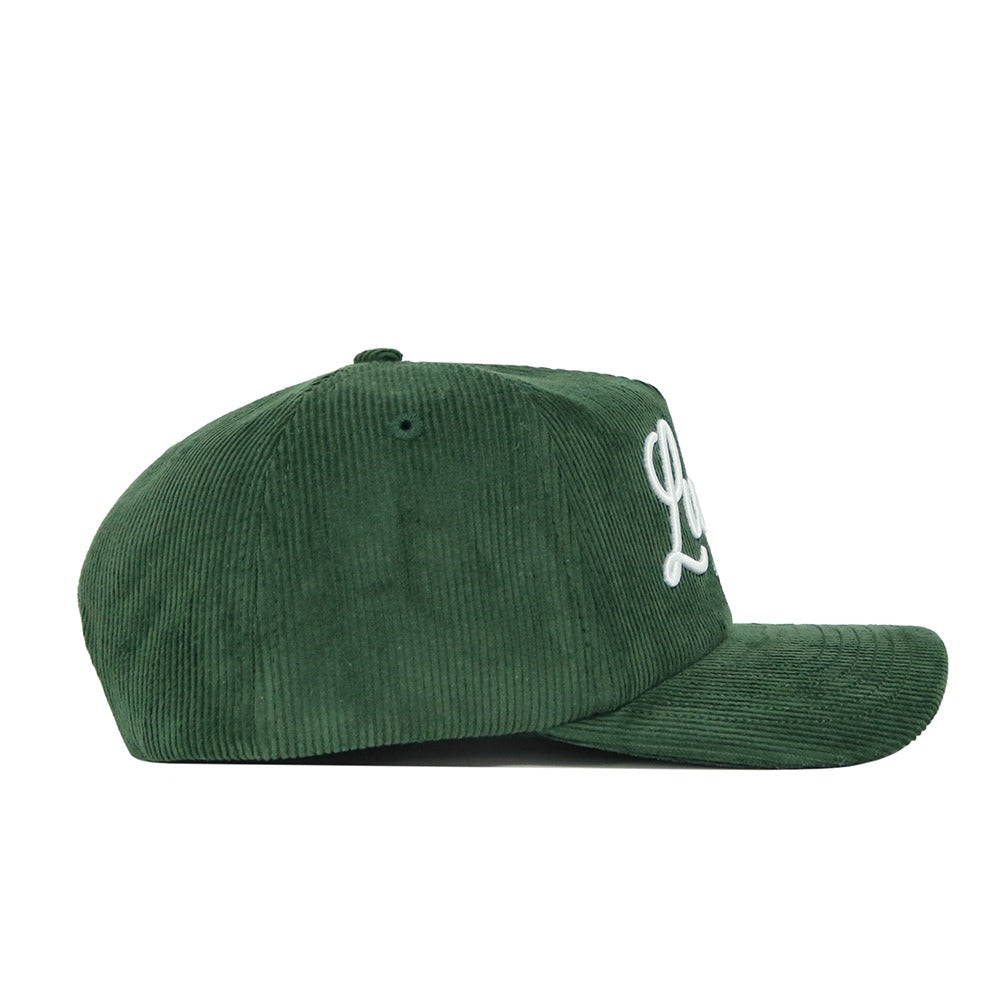 The No Rivals St.Pattys Lucky Cord Hat in green has an unstructured fit and a curved brim, viewed from the side with white embroidered lettering partly visible on the front.