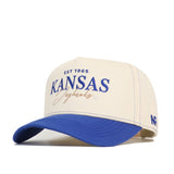 The No Rivals University of Kansas Vintage Hat is a beige and blue snapback cap made from premium cotton, featuring "EST 1865 KANSAS Jayhawks" embroidered in blue and gold, with blue stitching and a curved blue brim.