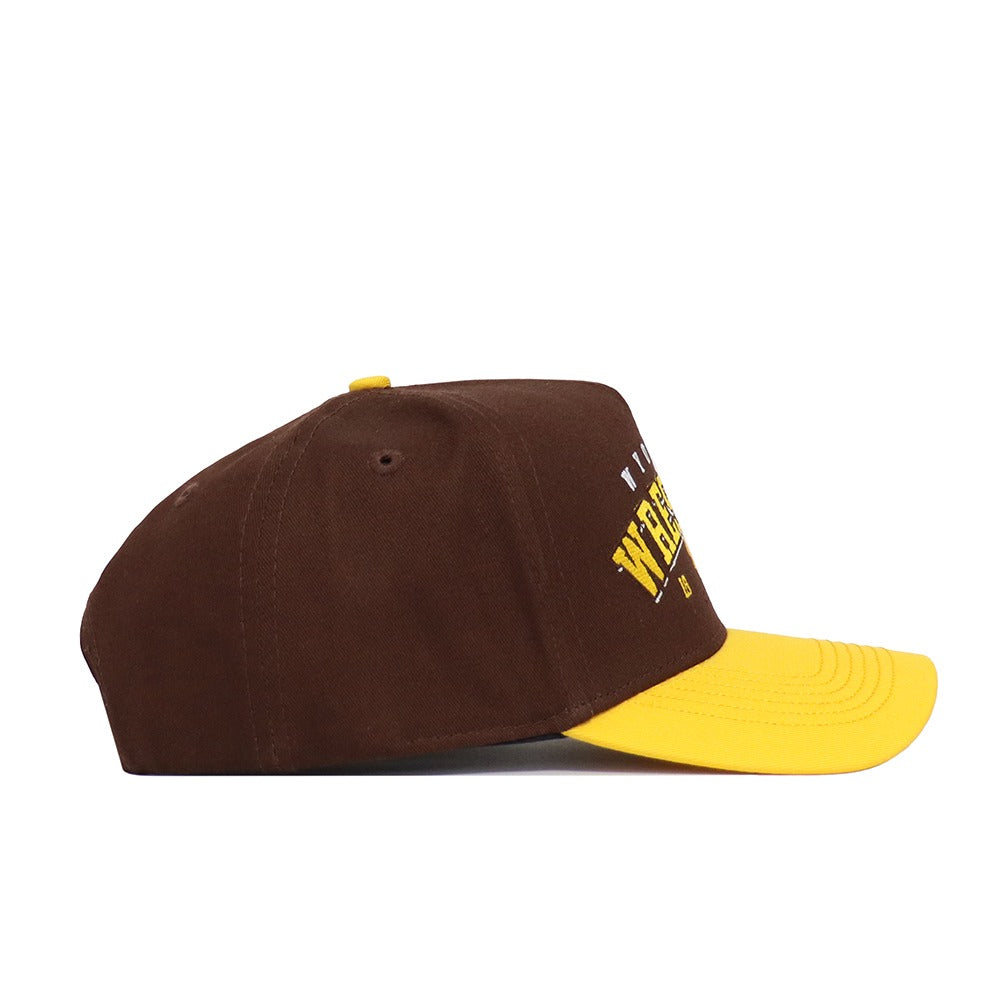 The No Rivals Wyoming Wrestling Hat - Takedown Collection is a brown cotton dad cap with a yellow brim and top button, shown from the side. Partially visible on the front is yellow embroidered text.