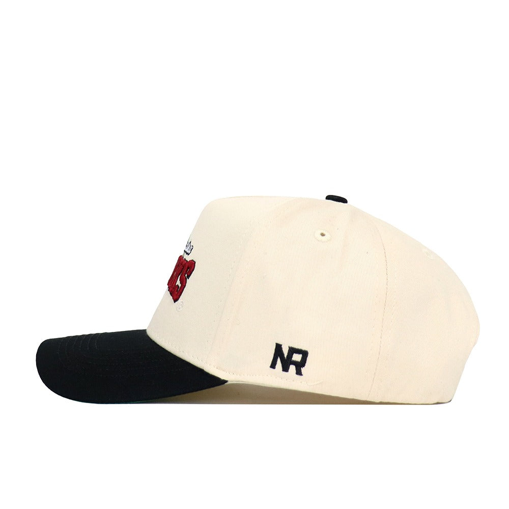 The No Rivals South Carolina Ballpark Hat is a beige snapback baseball cap with a black brim, made of high-quality cotton. Side view shows embroidered black NR initials at the back and a partial red and black front design.