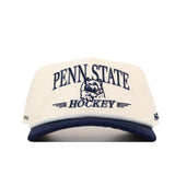 The No Rivals Penn State Hockey Hat is officially licensed, cream-colored with a navy brim, snapback closure, and durable cotton fabric. The front features embroidered Penn State logo and Nittany Lion graphics.