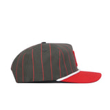 The Nebraska Gray Unstructured Hat by No Rivals features a dark gray design with thin red pinstripes, a red flat brim, and white trim above the brim. Made from high-quality cotton, it’s shown in a side profile on a white background.