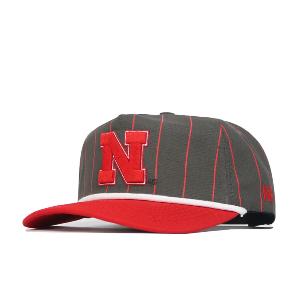 The No Rivals Nebraska Gray Unstructured Hat features soft cotton with thin red stripes, a red brim, a bold red N on the front, white accent above the brim, and a small red N on the side.