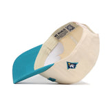 The Upside Down Seahawks Hat - UNCW - Classic Colors by No Rivals is a cream snapback with a teal brim, blue and yellow side patch, and an inside label reading NO RIVALS. Made from premium cotton. Shown here upside down.