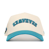 The No Rivals Upside Down Seahawks Hat - UNCW - Classic Colors features a cream snapback, turquoise brim, and blue SEAHAWKS lettering flipped on the front. Made from high-quality cotton for a comfortable, structured fit.