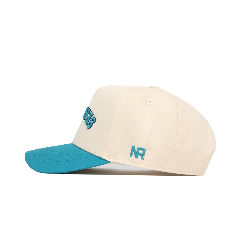 The Upside Down Seahawks Hat - UNCW by No Rivals features classic colors with a cream cotton build, teal blue brim, NR teal embroidery on the side, and partially visible blue lettering on the structured front.