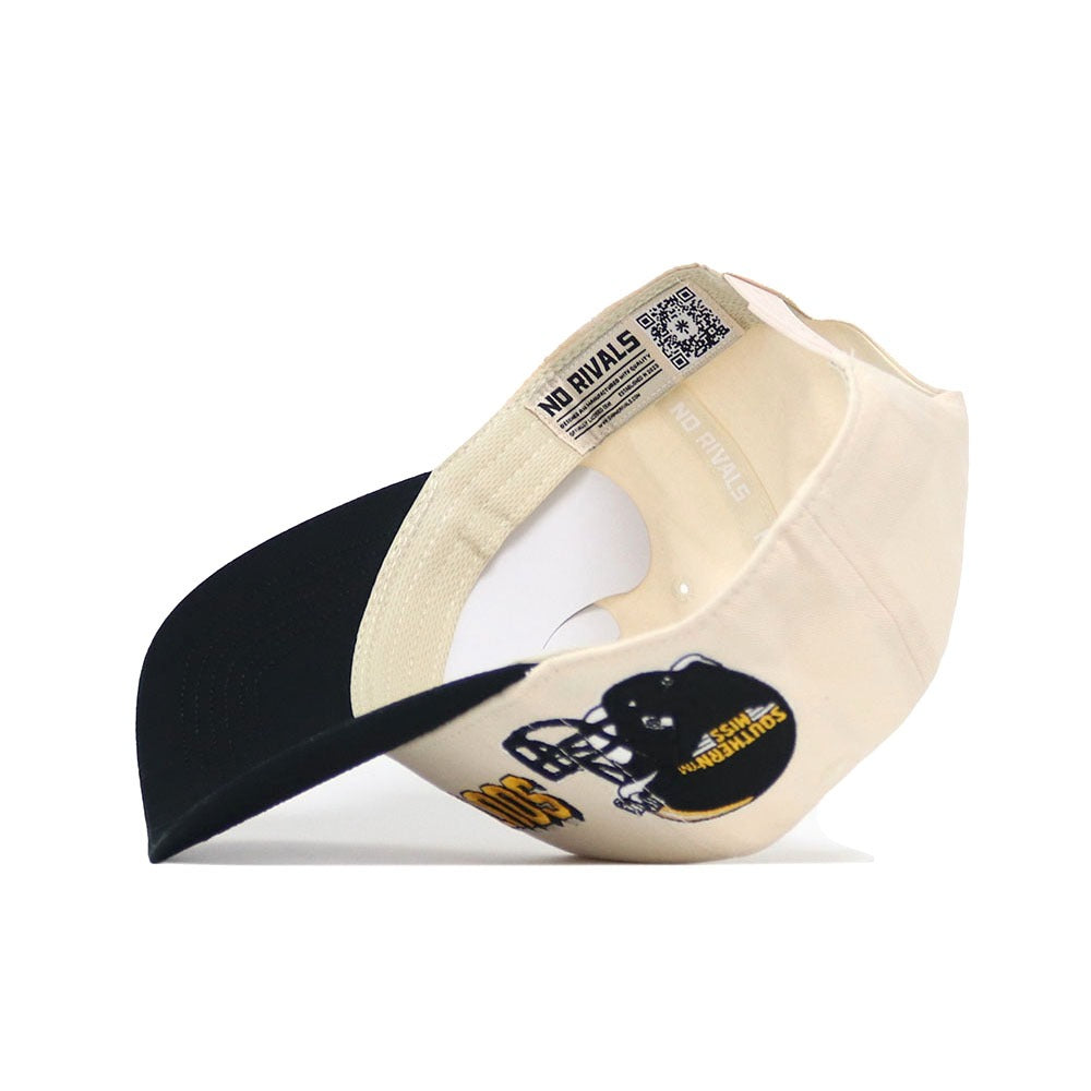 The Southern Miss Alma Mater Hat by No Rivals is a beige and black snapback baseball cap turned upside down, displaying inside details—embroidered logos, a graphic of a football player in a black helmet, and “NO RIVALS” on the inner band.