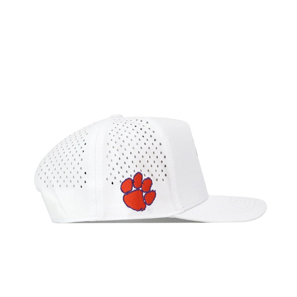 The Clemson Golf Hat - Swinging in White by No Rivals features ventilation holes, an orange embroidered paw print logo on the side, and a classic snapback closure for an adjustable fit.