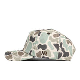 The Alabama Crimson Tide Huntsman Hat by No Rivals features a camouflage pattern in shades of green, beige, and black, crafted from high-quality cotton and accented with the embroidered letters “NR” on the side.