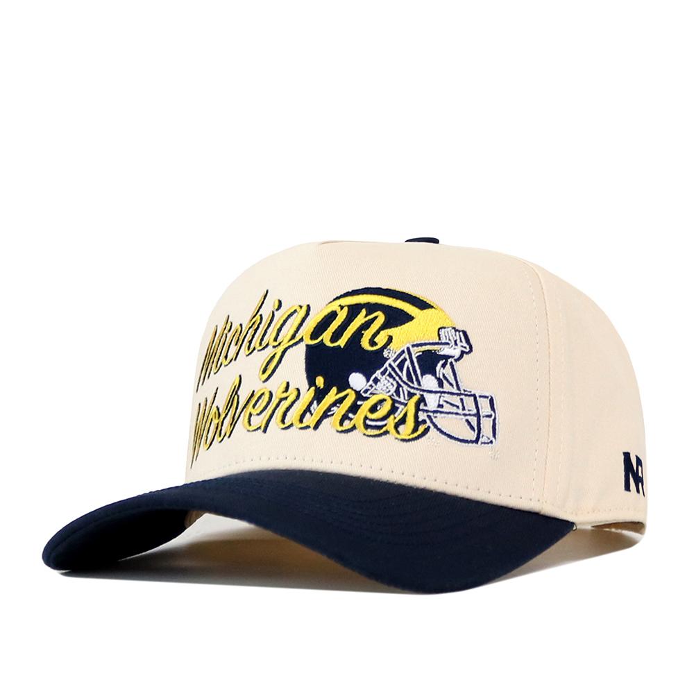 Show off your team pride with the No Rivals Michigan Wolverines Script Overlay Hat, a beige snapback cap with a black brim. This officially licensed hat features bold Michigan Wolverines text, a football helmet graphic, and an embroidered yellow wolverine logo on the front—making it the perfect choice for any fan.