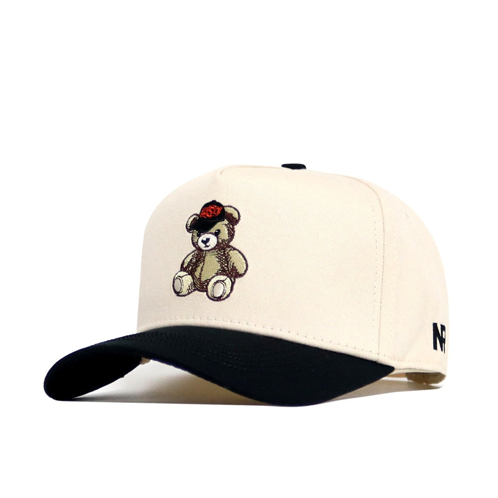 The No Rivals OSU Bear Hat is a beige structured cap with a black curved brim, teddy bear embroidery on the front, NR logo on the side, and an adjustable snapback closure.