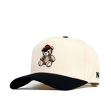The No Rivals OSU Bear Hat is a beige structured cap with a black curved brim, teddy bear embroidery on the front, NR logo on the side, and an adjustable snapback closure.